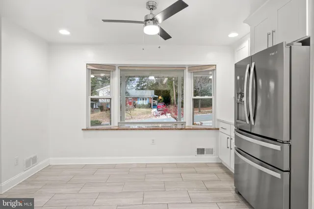 view of kitchen with stainless steel appliances granite countertop a refrigerator and a sink
