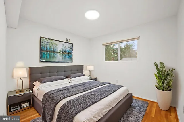 a bedroom with a bed and a painting on the wall