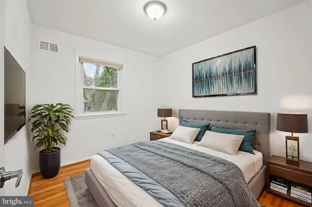 a bedroom with a bed and a potted plant