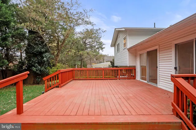 a balcony with wooden floor and yard in the back