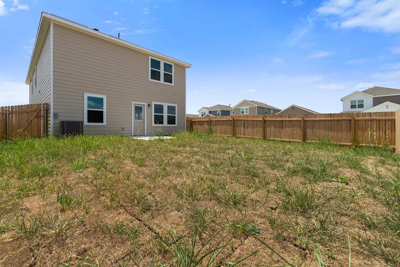 101 Aoudad Road Hutto, TX 78634 - Photo 37 of 39 A spacious backyard enclosed by a wooden fence, offering ample space for outdoor activities.
