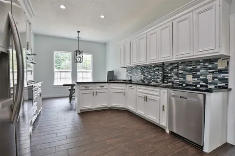 a kitchen with white cabinets and window