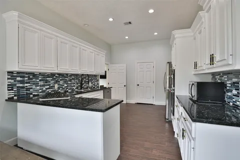 a kitchen with granite countertop a sink and a stove top oven