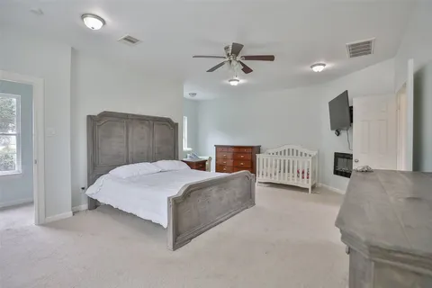 a spacious bedroom with a bed and a chandelier