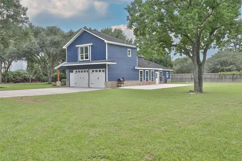 a view of a house with a yard and a tree