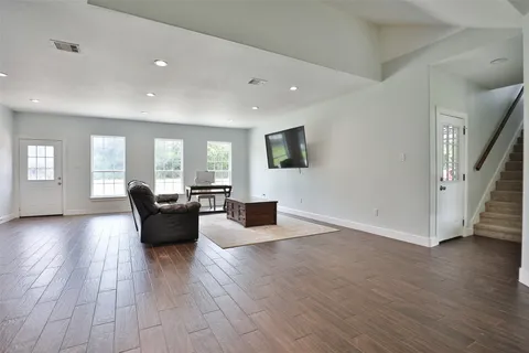 a living room with furniture and a wooden floor