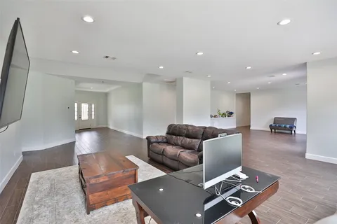 a living room with furniture and a wooden floor