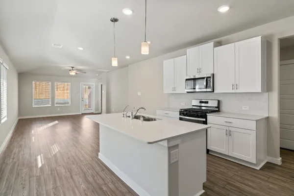 a kitchen with a sink a stove a microwave and cabinets