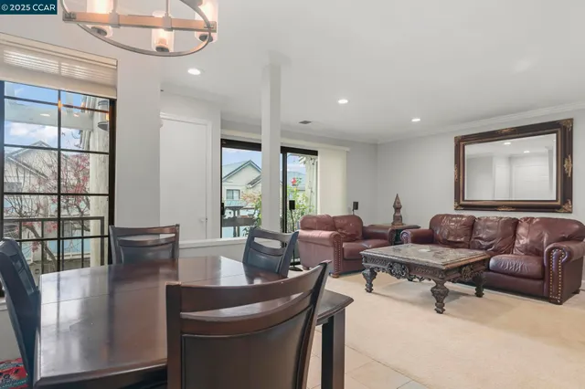 a kitchen with a dining table chairs cabinets and stainless steel appliances