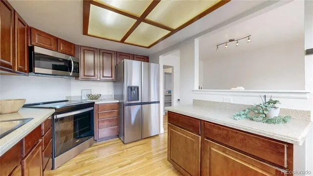 a kitchen with kitchen island granite countertop a sink stainless steel appliances and cabinets