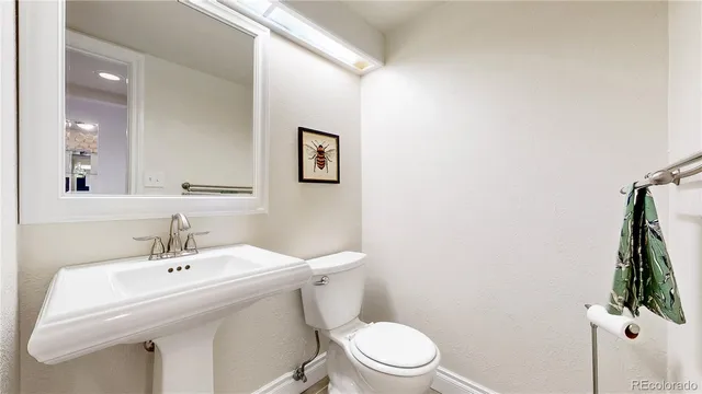 a bathroom with a sink mirror and toilet