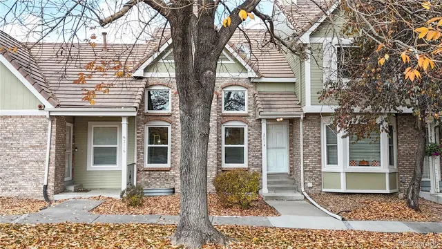 a view of a brick house with large windows and a tree