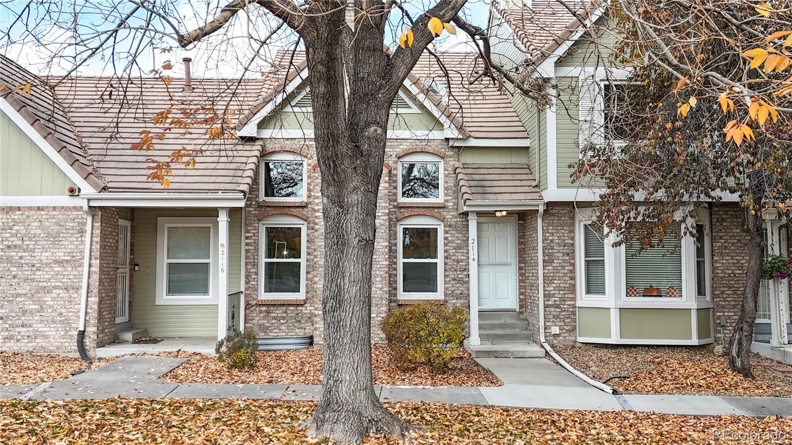 2114 Ranch Drive Denver, CO 80234 - Photo 36 of 48 a view of a brick house with large windows and a tree