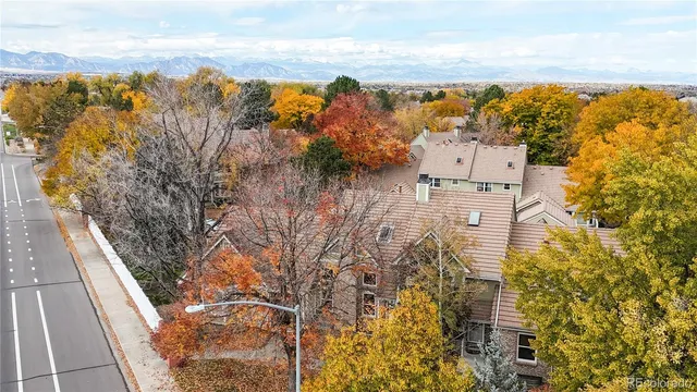 an aerial view of a house with swimming pool and trees