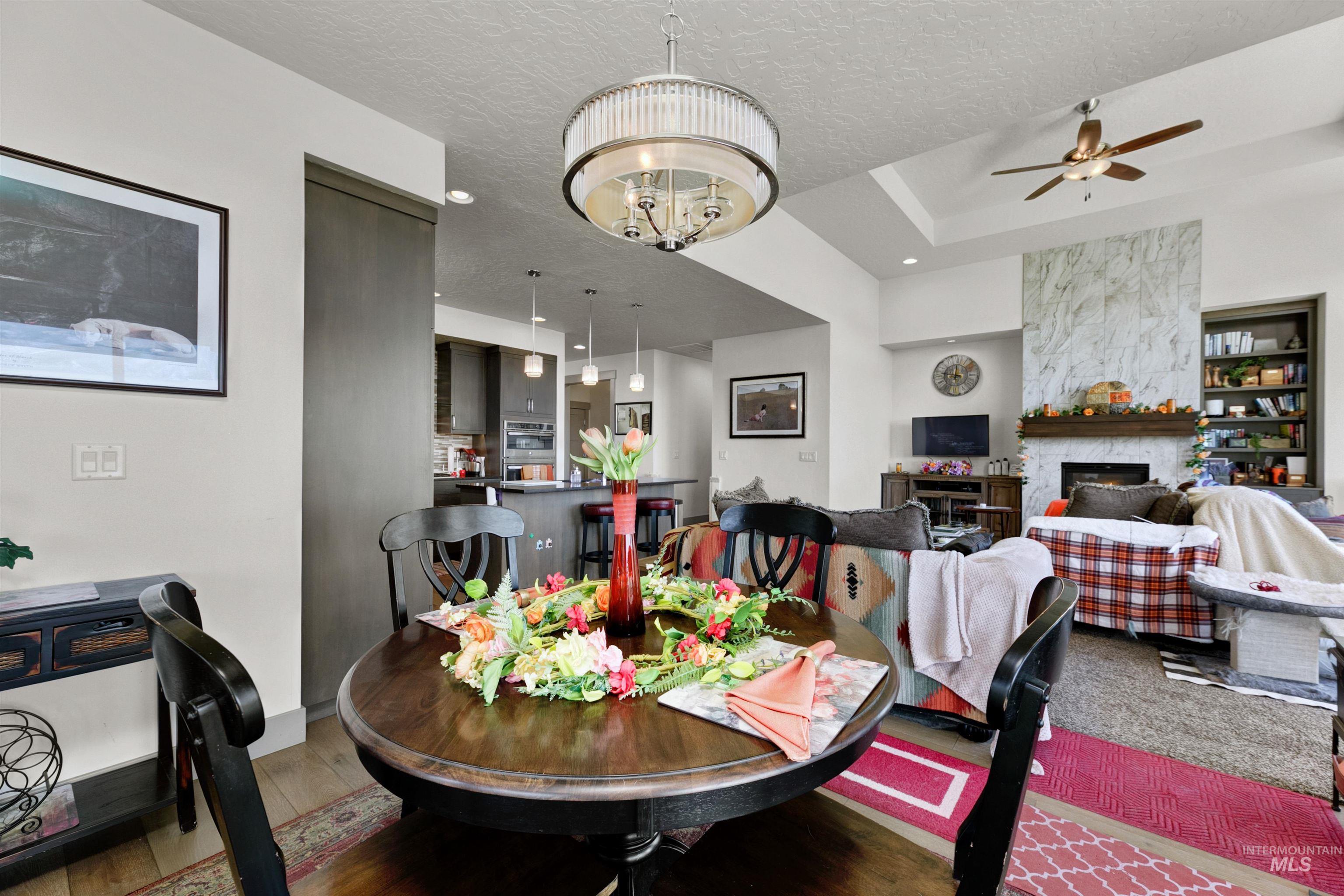 24398 Tombstone Ridge Court Middleton, ID 83644 - Photo 31 of 47 Open-concept living space featuring a dining area with a circular wood-finish table and a contemporary chandelier