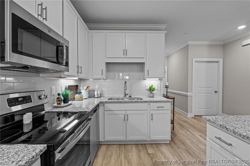 200 Gallery Drive, Unit 101 Spring Lake, NC 28390 - Photo 6 of 17 a kitchen with stainless steel appliances granite countertop a stove a sink and a microwave