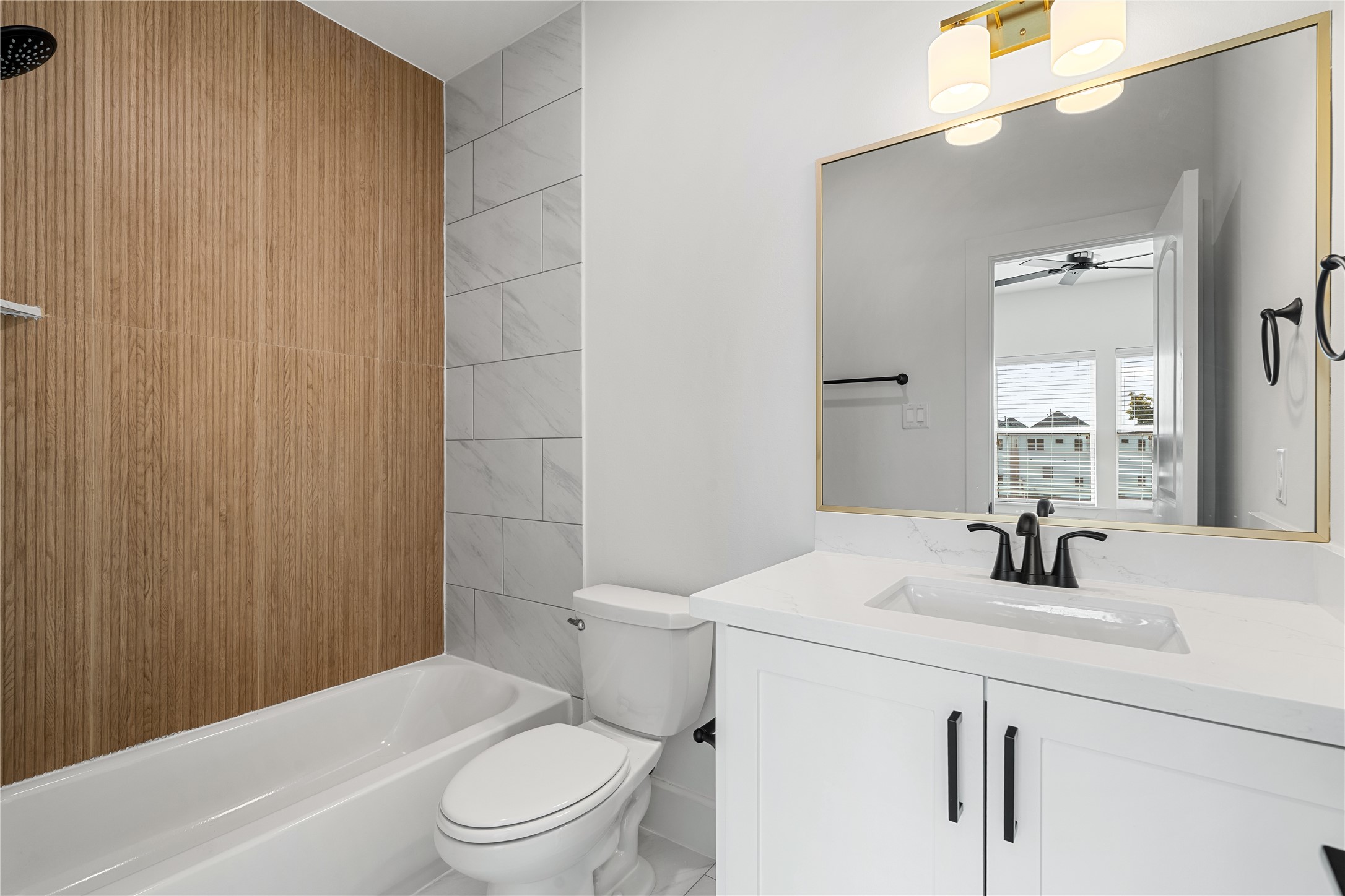 1614 Ojeman Road, Unit I Houston, TX 77055 - Photo 42 of 49 Beautiful en-suite full bathroom located in the third-floor secondary bedroom, featuring modern finishes, a quartz vanity, and a stylish wood-accented shower wall.