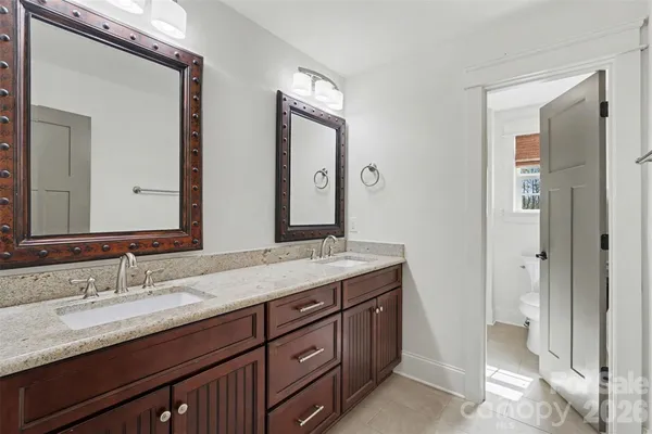 a bathroom with double vanity sinks and a mirror