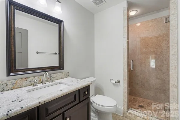 a bathroom with a granite countertop sink toilet and shower