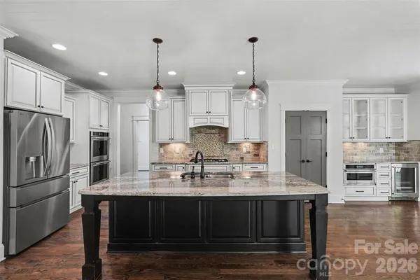 a kitchen with kitchen island white cabinets and stainless steel appliances