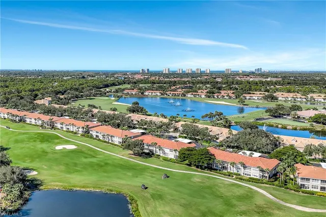 an aerial view of residential houses with outdoor space and trees