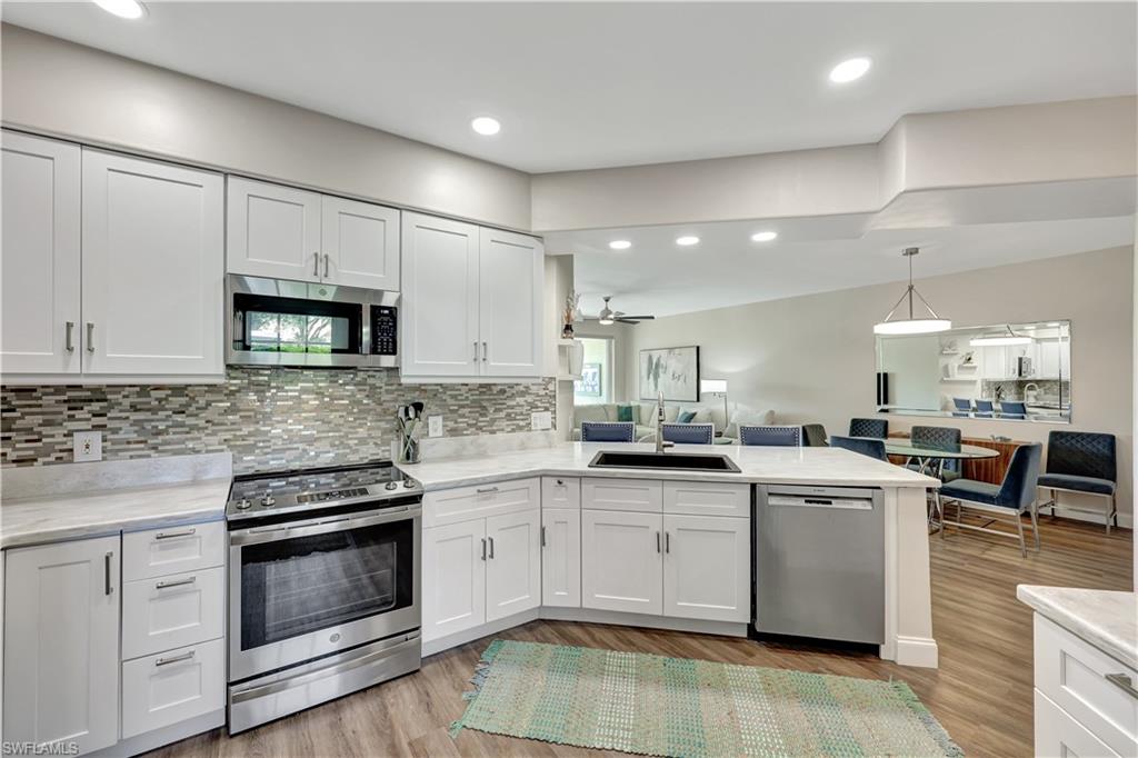 9020 Spring Run Boulevard, Unit 604 Estero, FL 34135 - Photo 11 of 24 a kitchen with a sink stove and cabinets