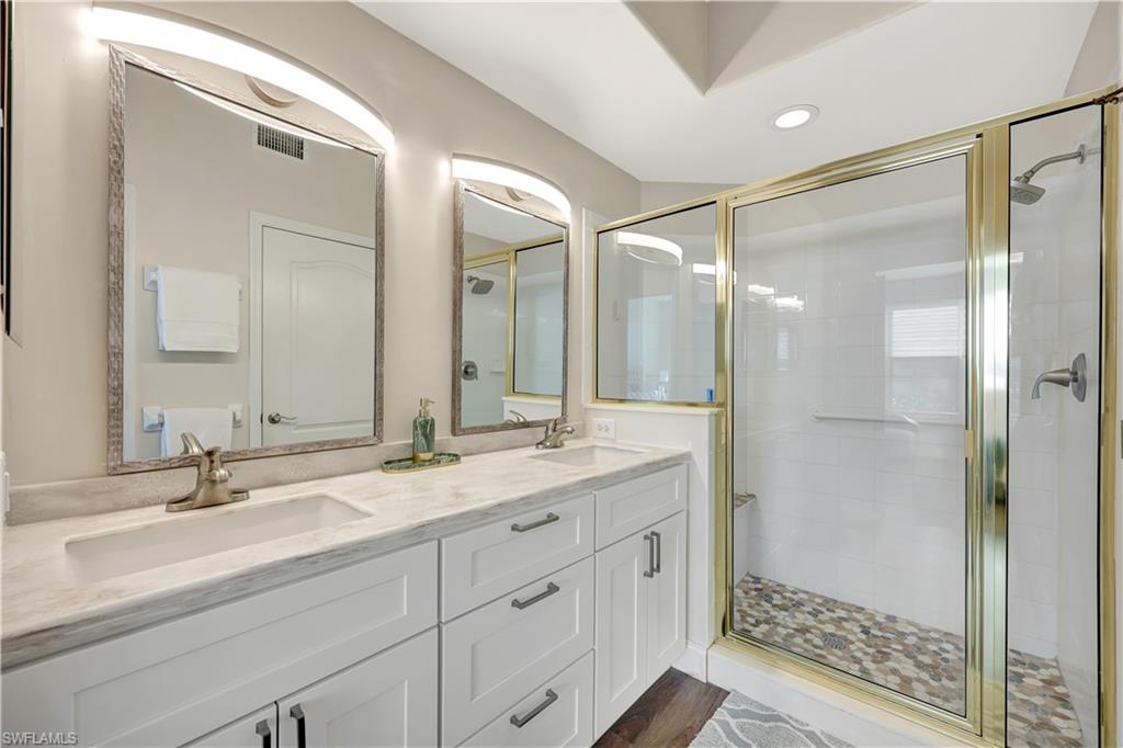9020 Spring Run Boulevard, Unit 604 Estero, FL 34135 - Photo 16 of 24 a bathroom with a shower sink and mirror