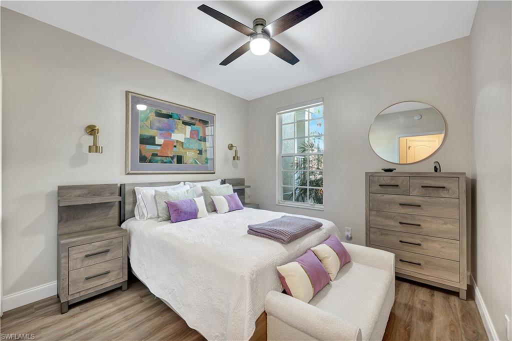 9020 Spring Run Boulevard, Unit 604 Estero, FL 34135 - Photo 17 of 24 a bedroom with a bed and wooden floor