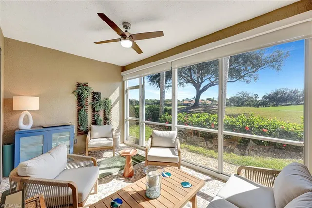 a living room with furniture floor to ceiling window and a floor to ceiling window