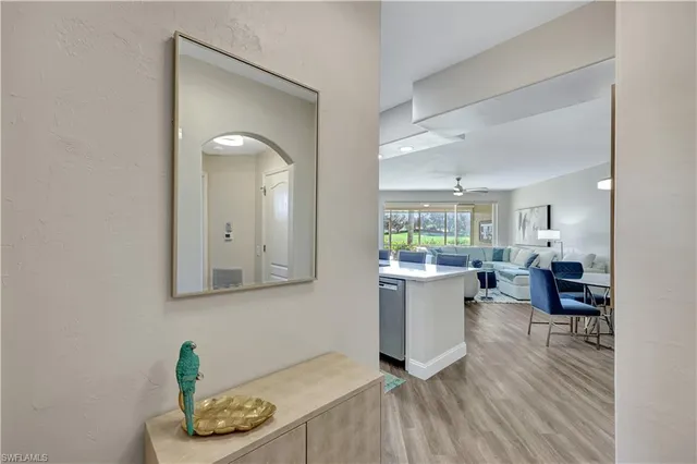 a room with a wooden floor and a kitchen view
