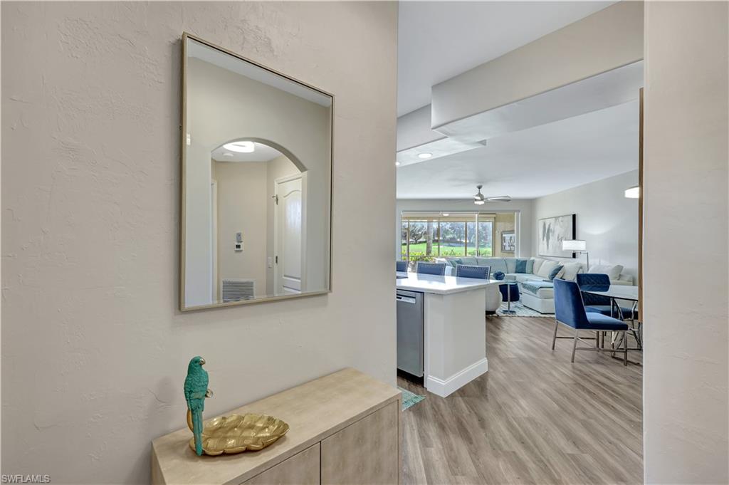 9020 Spring Run Boulevard, Unit 604 Estero, FL 34135 - Photo 5 of 24 a room with a wooden floor and a kitchen view