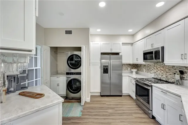 a kitchen with stainless steel appliances granite countertop a sink and a stove top oven with wooden floor
