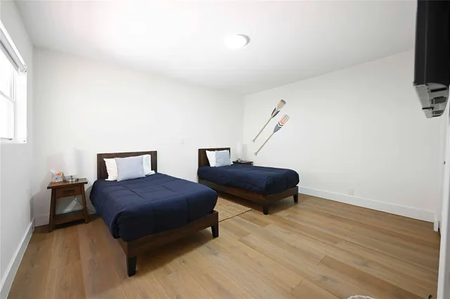 a bedroom with a bed and a flat tv screen on a dresser