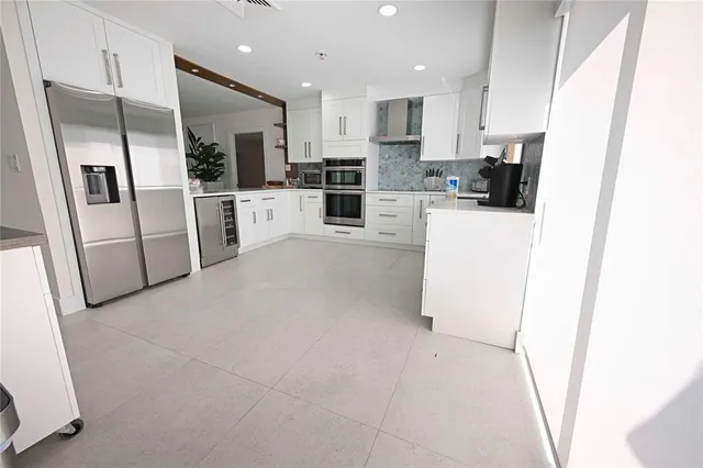 a kitchen with refrigerator a microwave and white cabinets