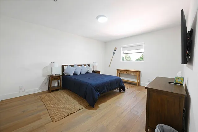 a bedroom with a bed and a flat tv screen on a dresser
