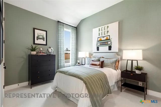 a bedroom with a bed and lamp on dresser