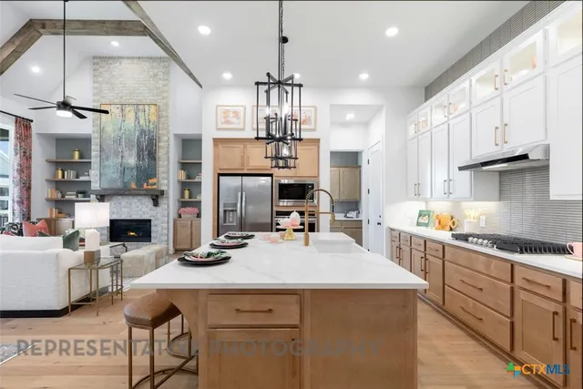 a kitchen with kitchen island granite countertop a sink cabinets and stainless steel appliances