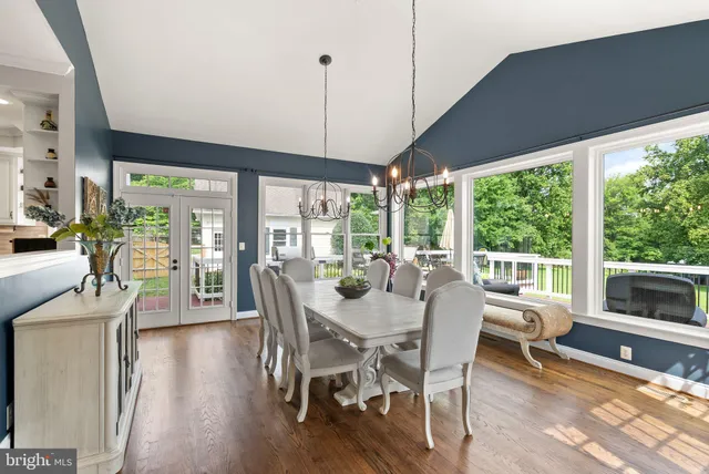 a spacious bedroom with a bed a couch and a flat tv screen on the dresser