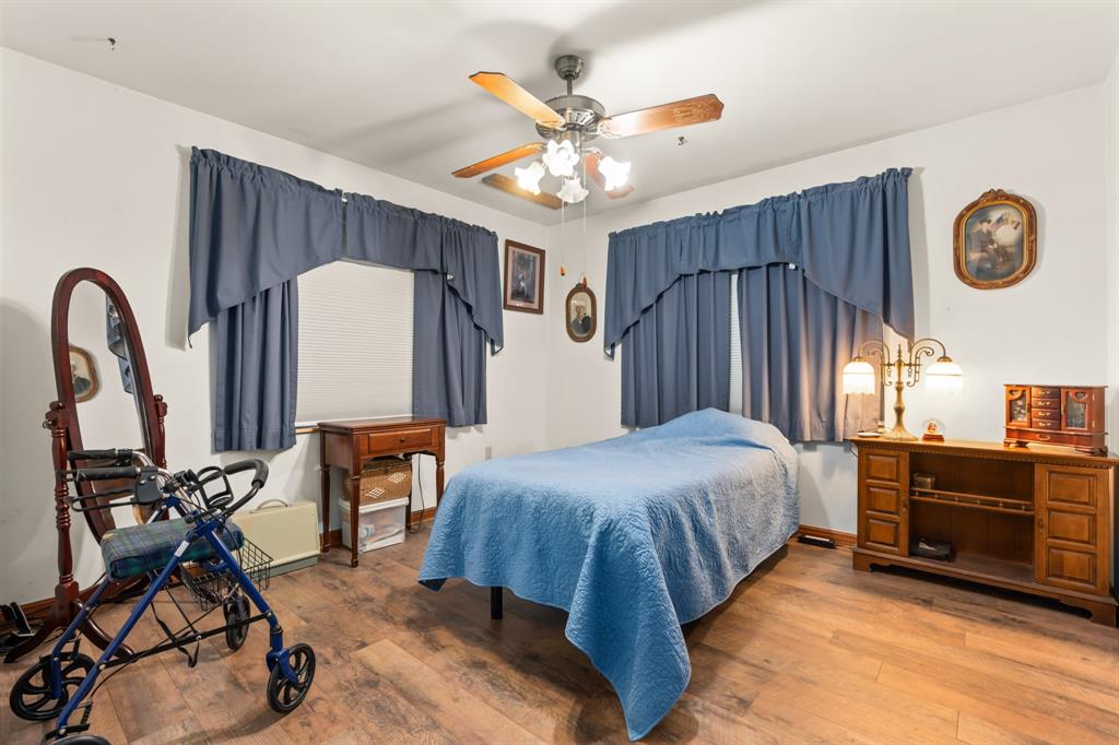 802 North Brazos Street Whitney, TX 76692 - Photo 17 of 33 a bed room with a bed and a chandelier