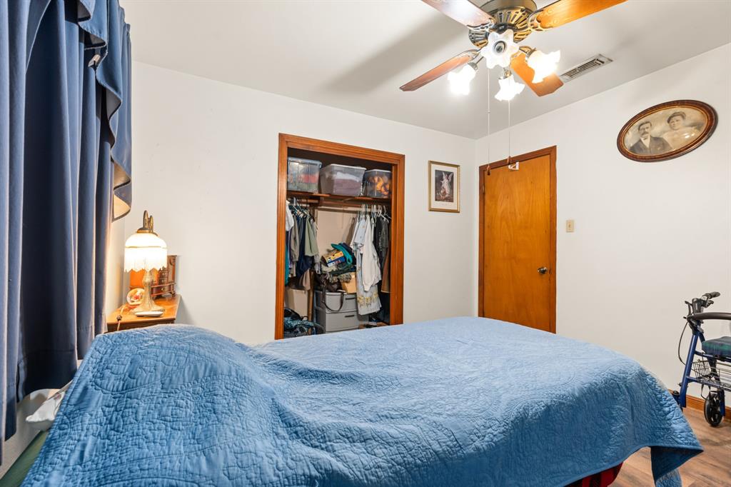 802 North Brazos Street Whitney, TX 76692 - Photo 18 of 33 a bedroom with a bed and a chandelier