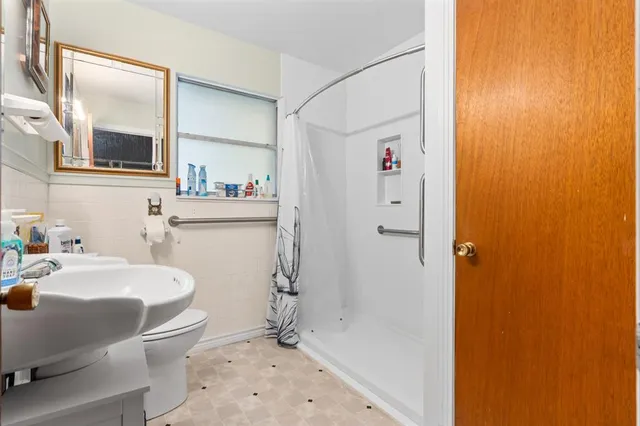 a bathroom with a sink a toilet and shower