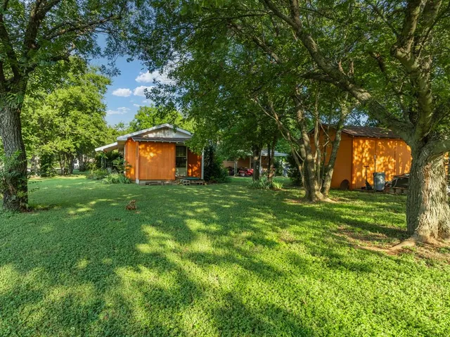 a view of a backyard with large trees