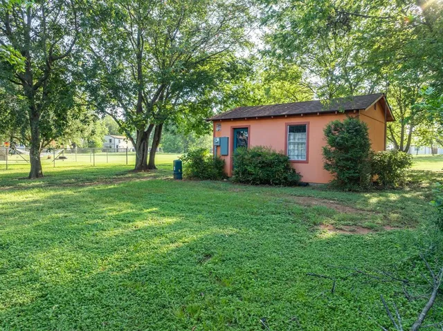 a view of backyard of house with green space