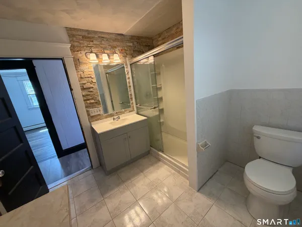 a bathroom with a toilet and a shower