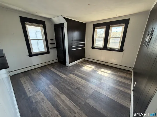 a view of an empty room window and wooden floor