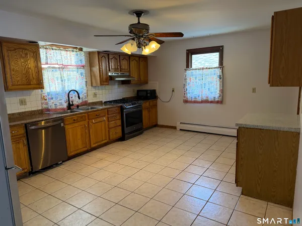 a kitchen with stainless steel appliances granite countertop a sink dishwasher stove top oven and cabinets