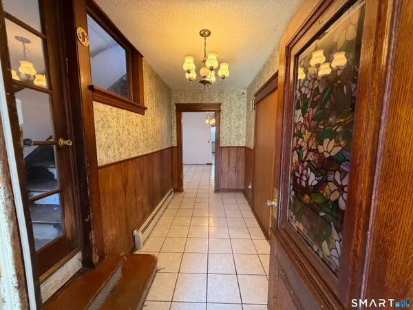 a hallway view with wooden floor and staircase