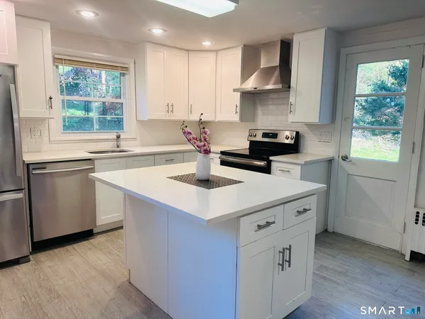 a kitchen with stainless steel appliances a sink stove and cabinets