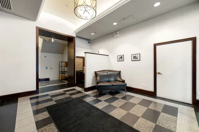 a living room with a black white checkered floor with couches chair and a coffee table
