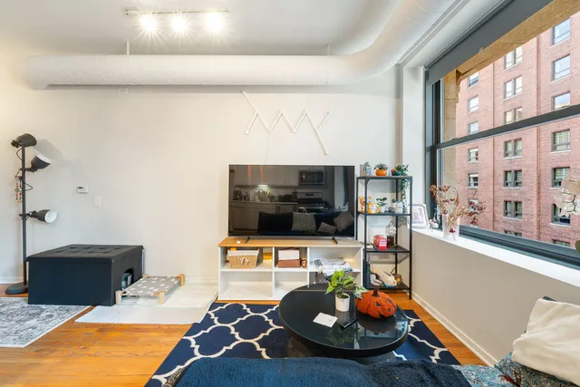 a room with furniture a flat screen tv and a floor to ceiling window